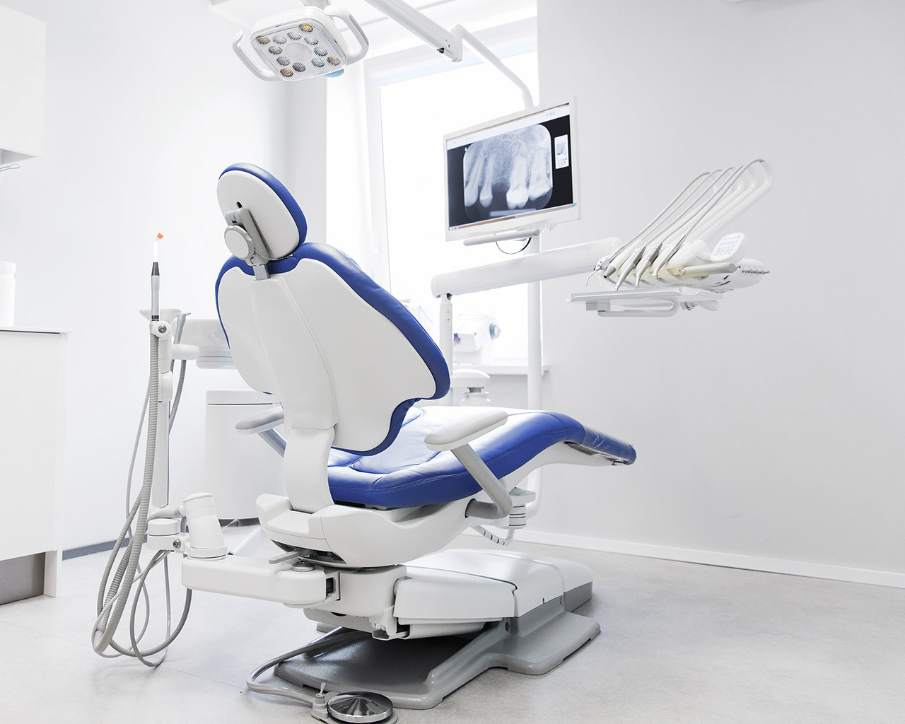 Modern dental office with examination chair and medical equipment.