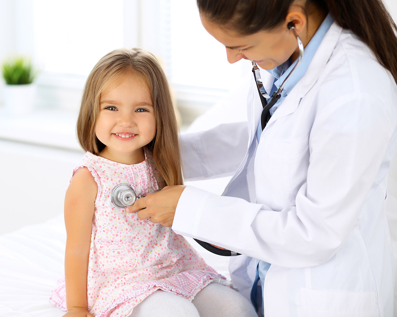 Pediatric doctor examining a young child during a routine healthcare visit.