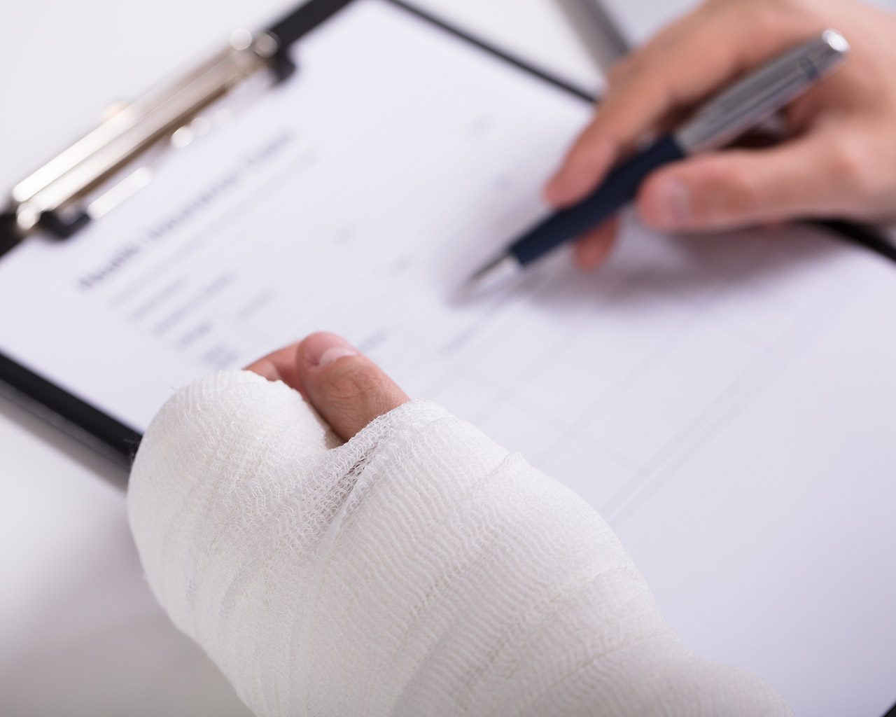 Employee completing healthcare paperwork after an injury consultation.